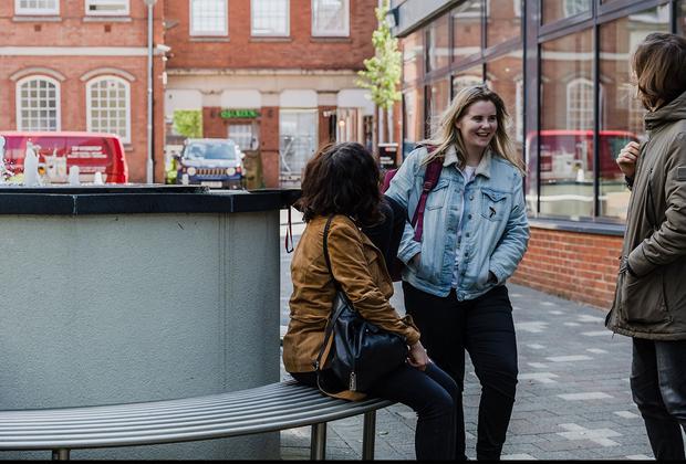 two girls walk along chatting outside middlesex university