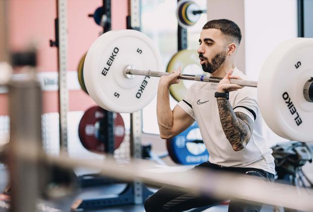 A student lifting weights at the gym in the West Stand