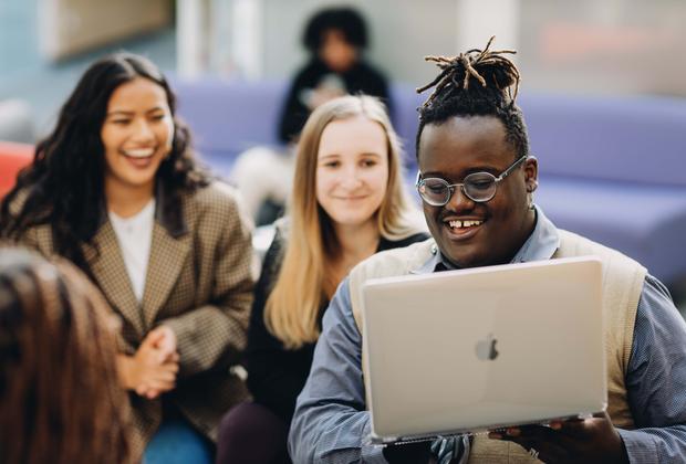 Three students looking at a laptop