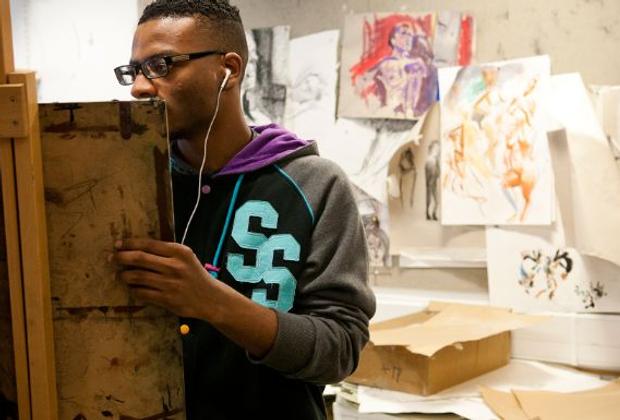 black student painting on easel