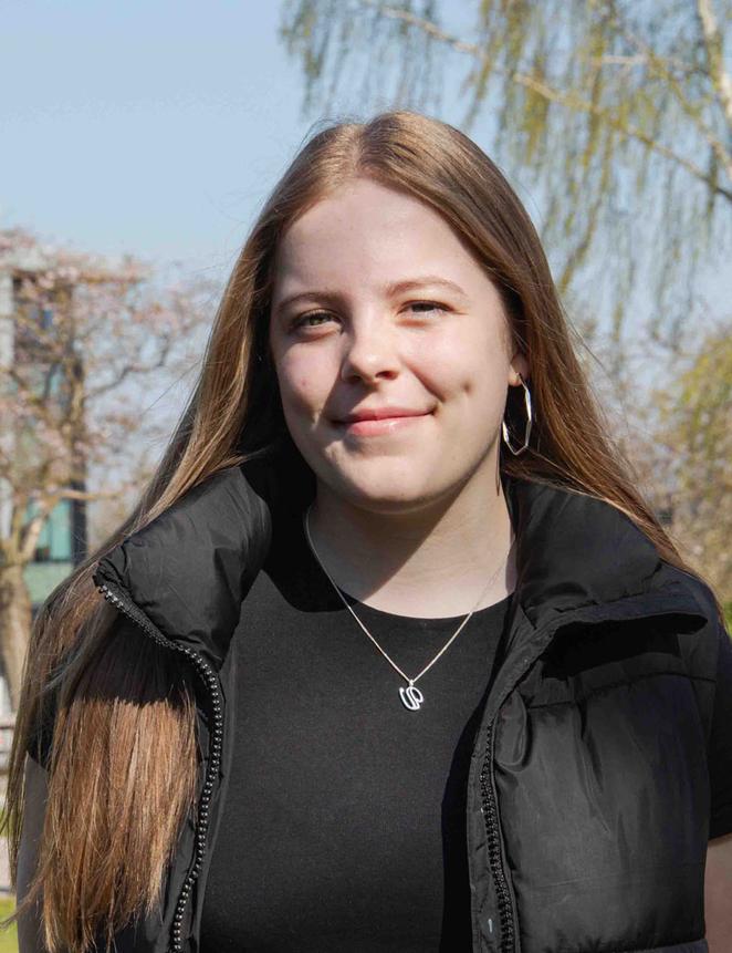 Abbi on campus on a sunny day with building in background