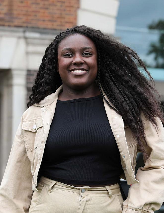 Peace - clearing student stood in front of gallery of work