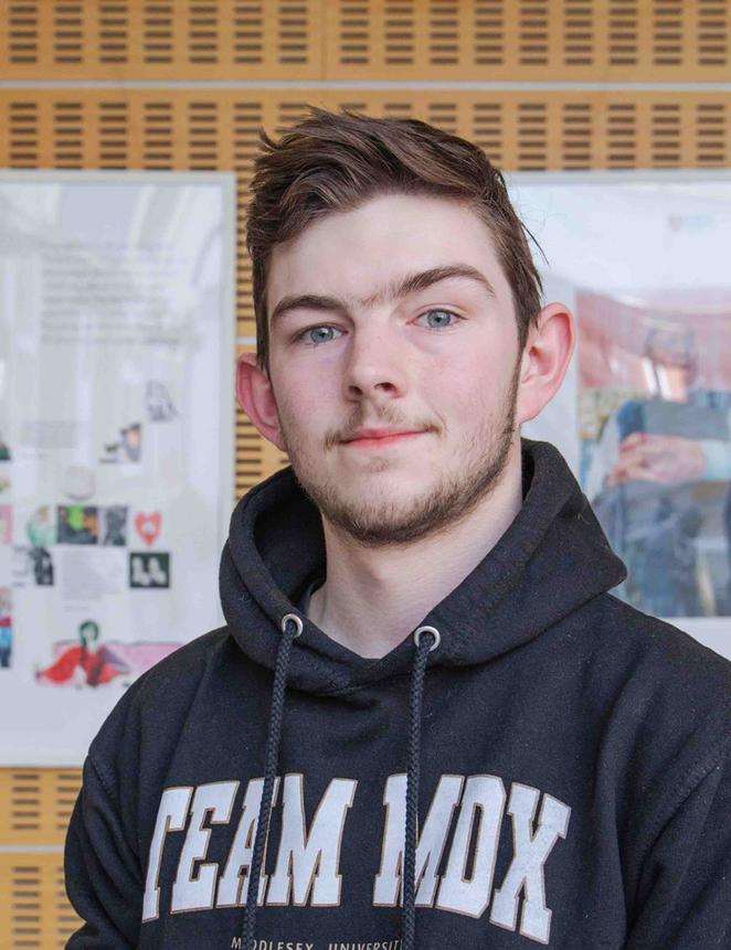 Toney - clearing student stood in front of gallery of work