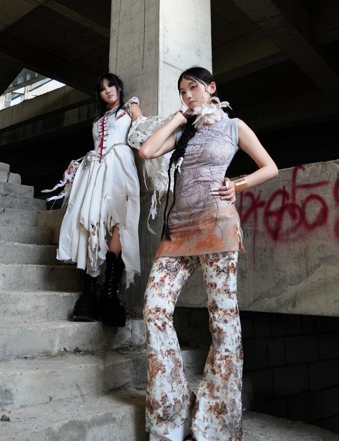 A design by Lin Wan Yi and Hu Ya Bing showing two women in front of a pillar with graffiti nearby