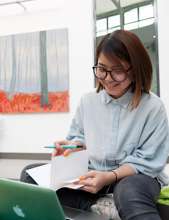 student working at laptop poses for picture