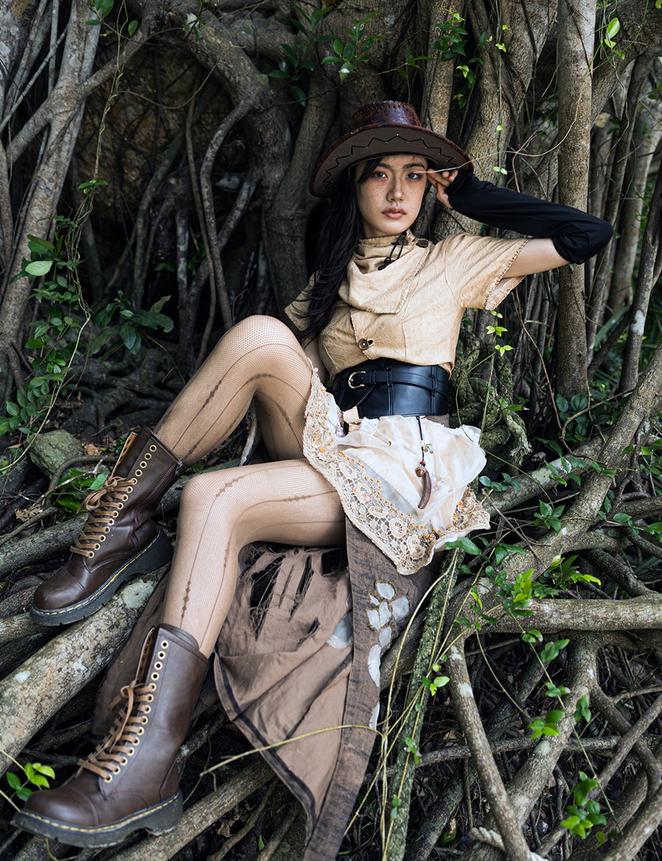 A work by designer Wu Yang showing a woman entangled by branches, inspired by the Strangling Ficus tree of the Hainan rainforest