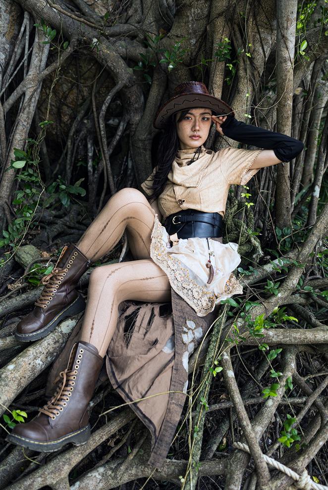 A work by designer Wu Yang showing a woman entangled by branches, inspired by the Strangling Ficus tree of the Hainan rainforest