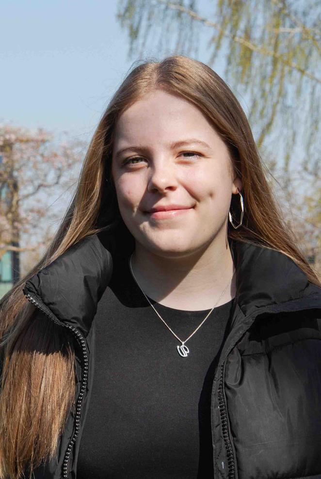 Abbi on campus on a sunny day with building in background