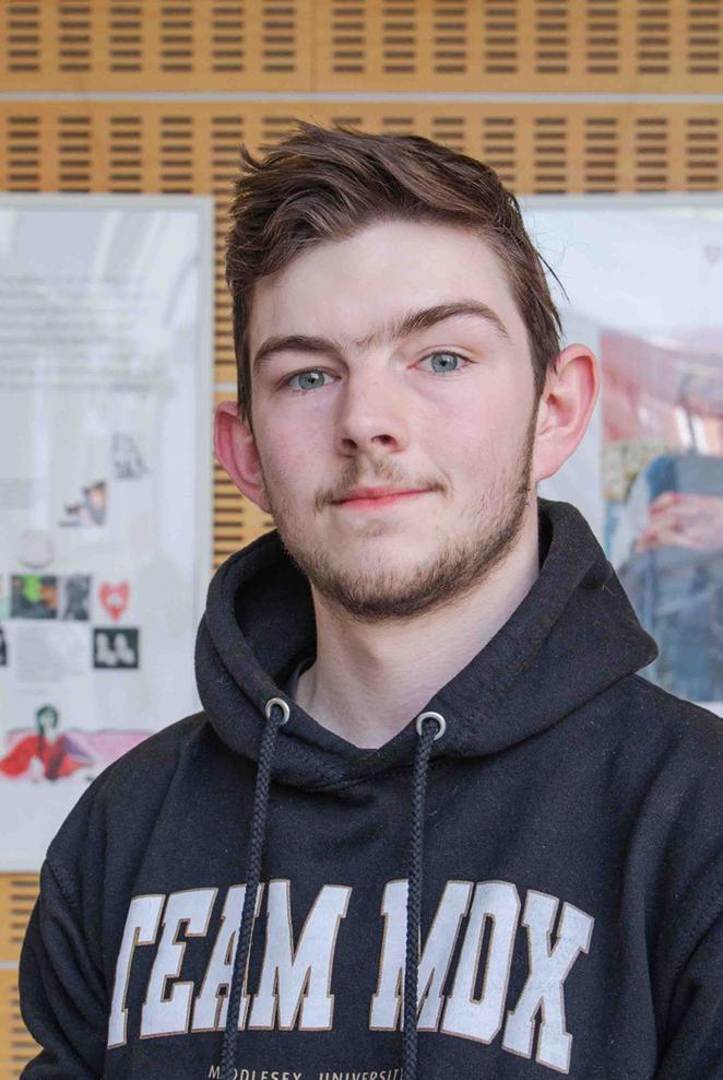 Toney - clearing student stood in front of gallery of work