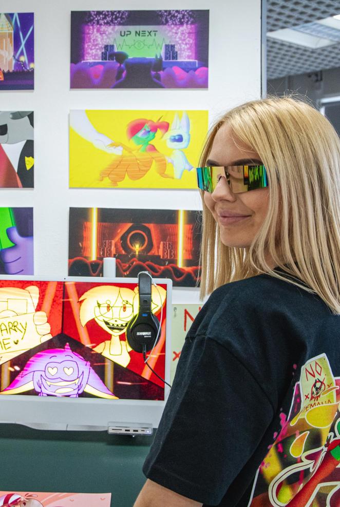 Middlesex student wearing glasses showcasing their work on the degree show