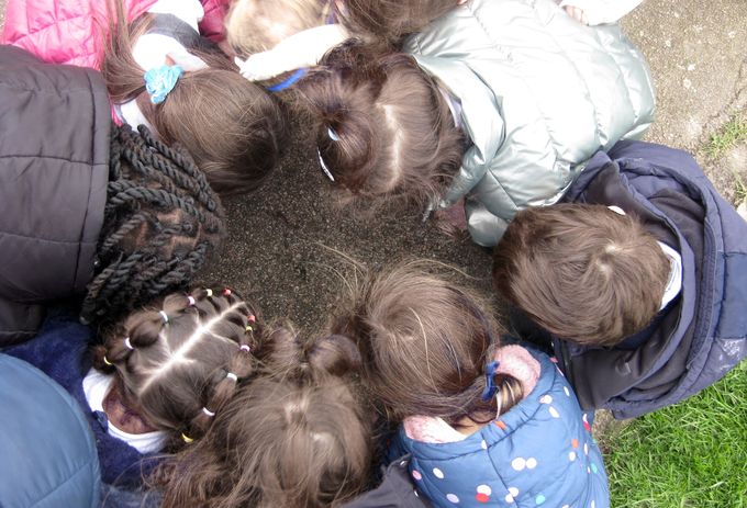 Children looking onto the ground