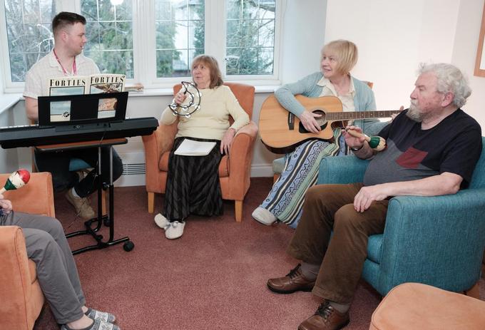 Group of people taking part in music session.