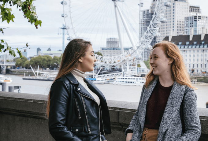 students by the river Thames, next to Westminster Bridge, London eye in the background