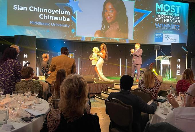 A student receiving her award at an awards ceremony, captivating the audience with her presence.