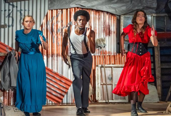 Three 91��ɫ students acting onstage in a live theatre production