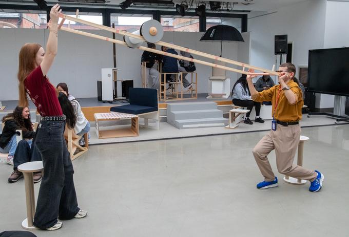 Two people interact with a roller in a studio