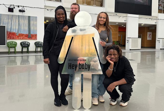 Four students standing with props from their awareness campaign