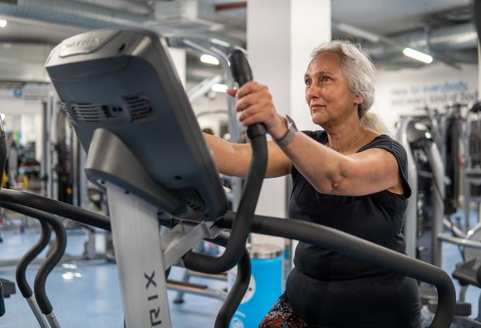 A woman is exercising on treadmill at gym
