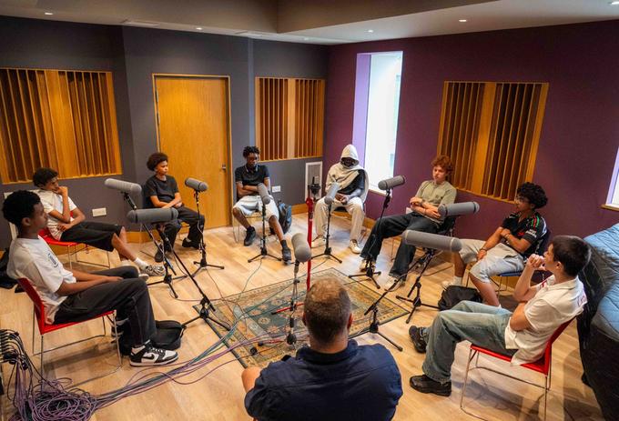 A group of male teenage students record a podcast as part of a project