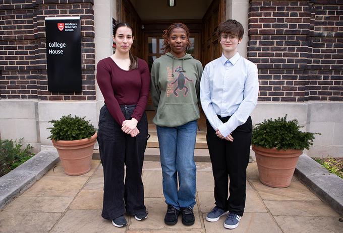 Students stand outside a building on campus