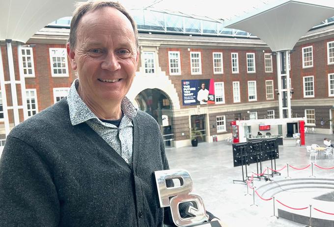 A man with an award in an atrium
