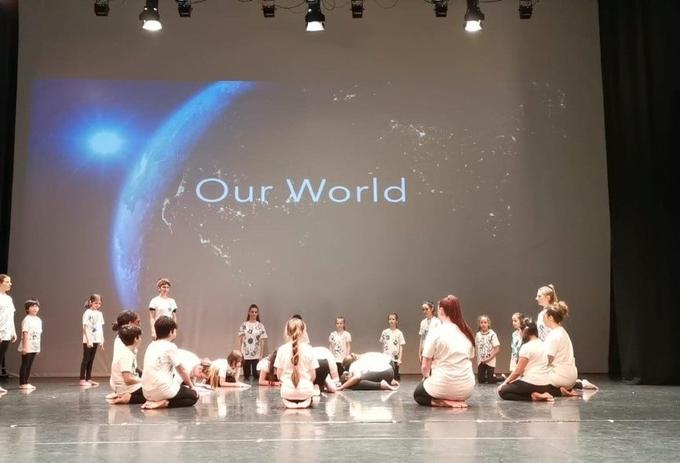 A picture of children dancing on stage