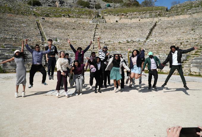 Students jump in the air at an ampitheatre