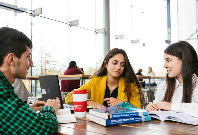 Three Business students working in a cafe
