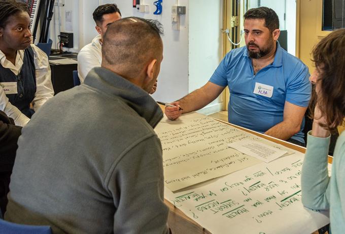People sat a table looking at a big sheet of paper
