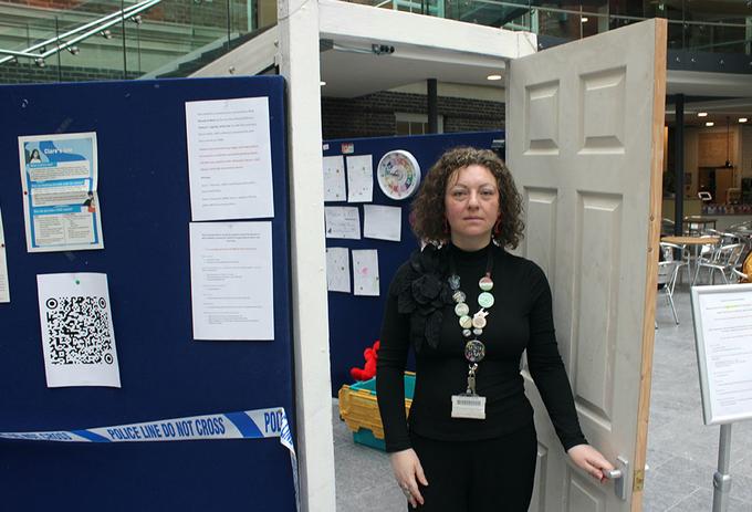 A woman stands outside an exhibition room