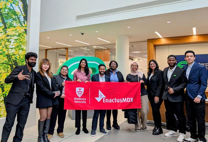 A team of students hold up a banner