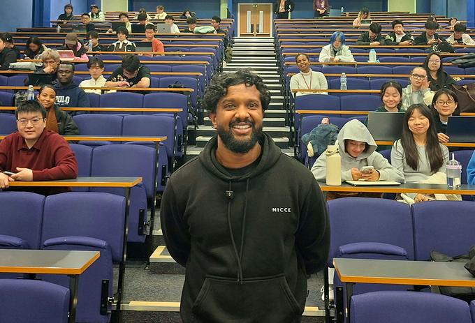 A man stands in a lecture theatre