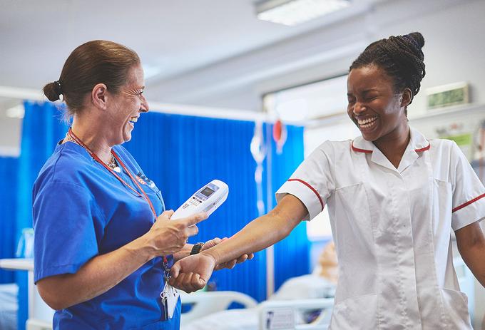 Nurses share a joke as they do a test on the ward