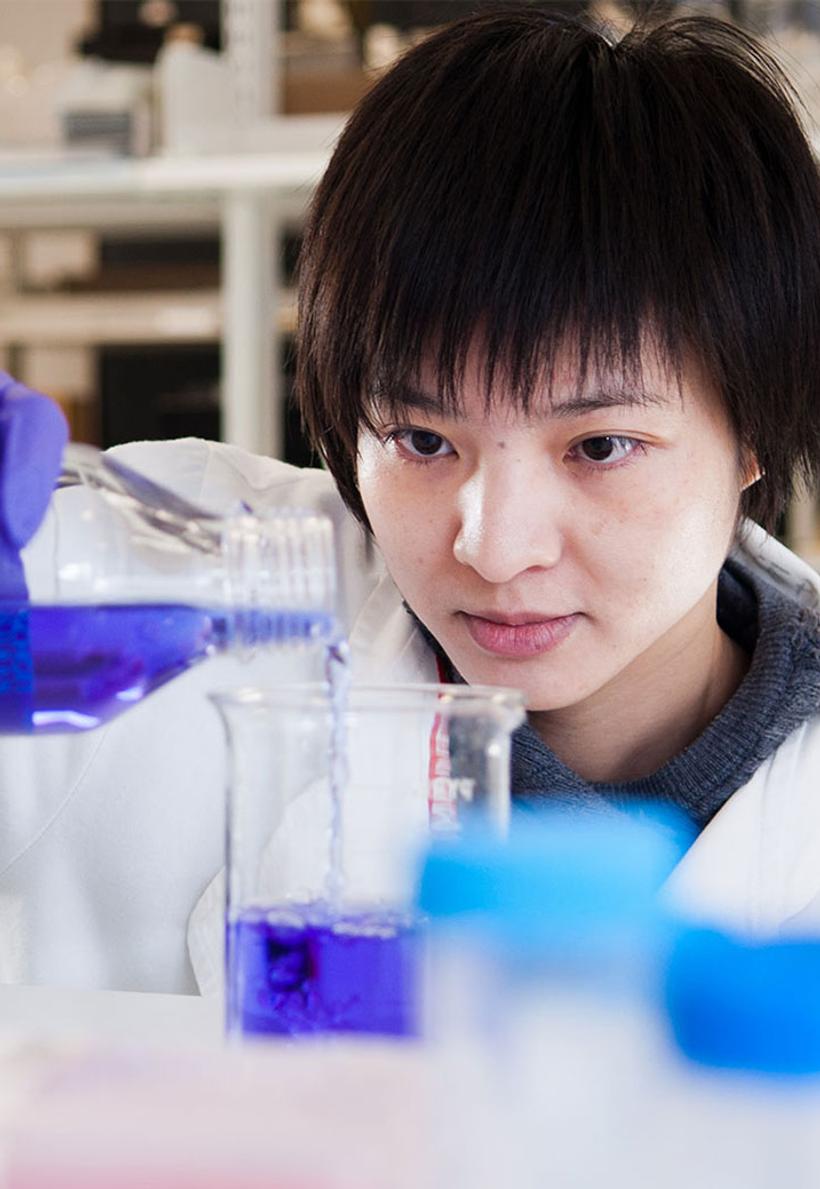 Student in a lab experimenting with chemicals