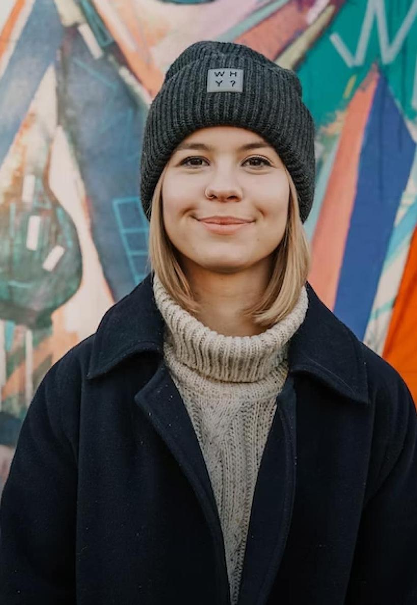 Person wearing hat in front of painted wall