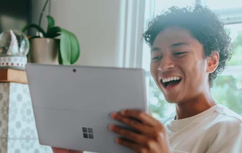Student laughing holding tablet