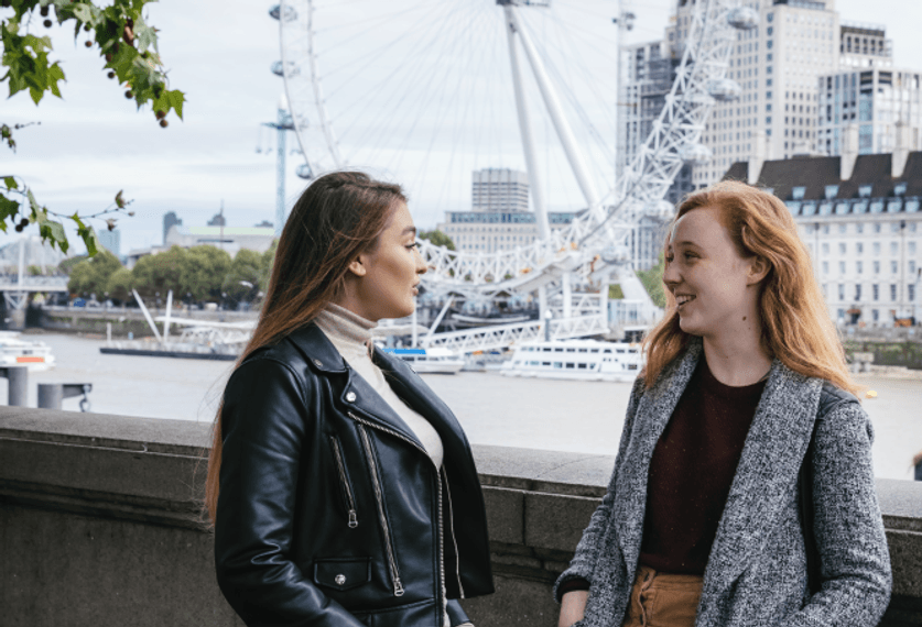 students by the river Thames, next to Westminster Bridge, London eye in the background