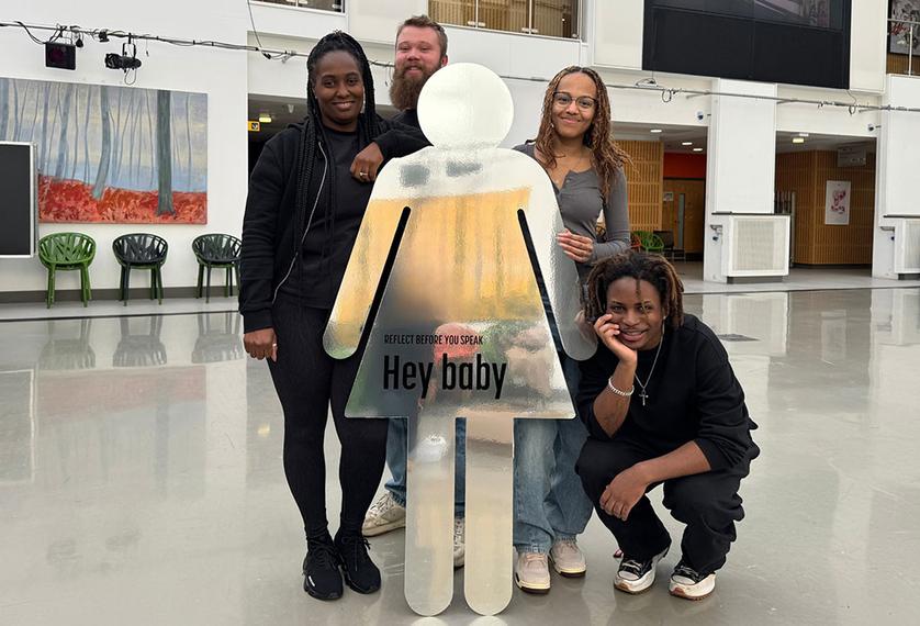 Four students standing with props from their awareness campaign