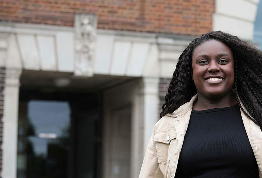 Peace - clearing student stood in front of gallery of work