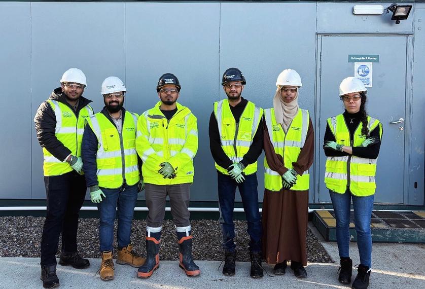 Students look at camera on a construction site