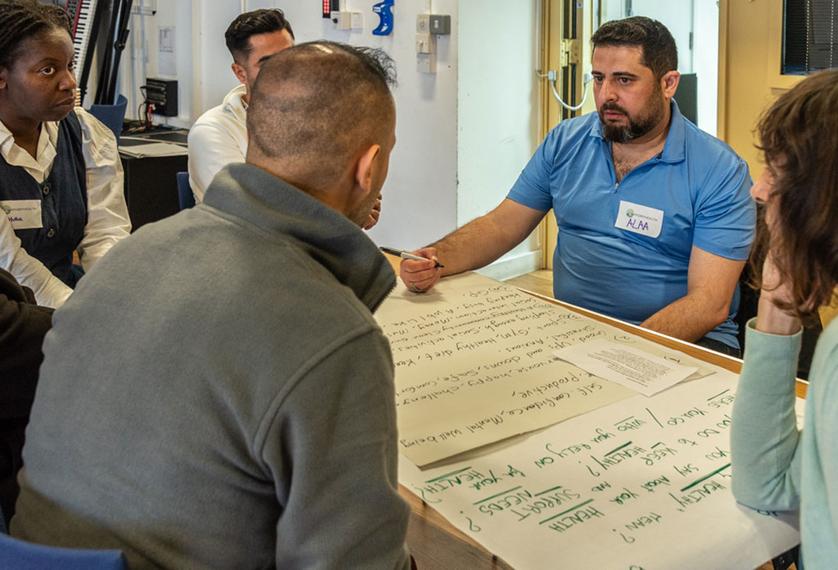 People sat a table looking at a big sheet of paper