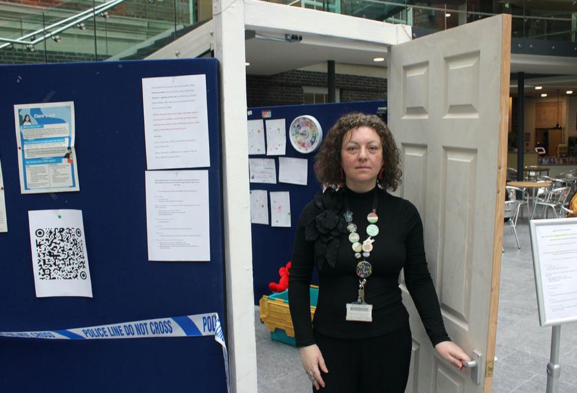 A woman stands outside an exhibition room
