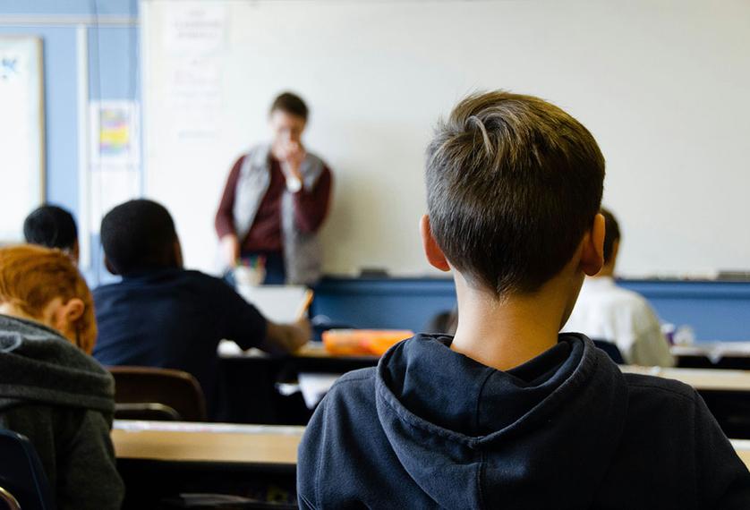 A boy sits in a classroom during a lesson