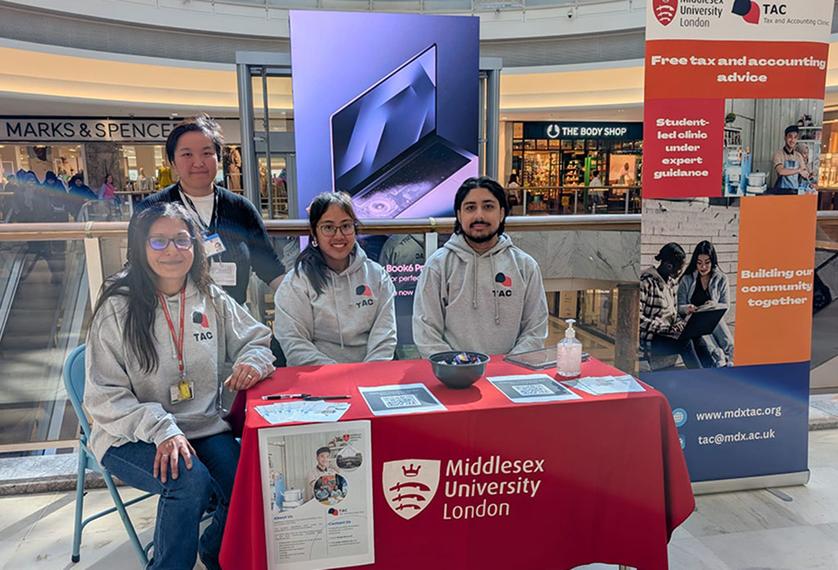 Students at a stand offering tax advice in a shopping centre