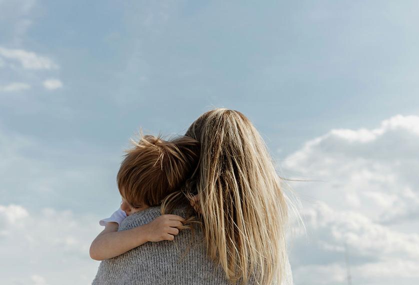 A woman with long hair holds a child