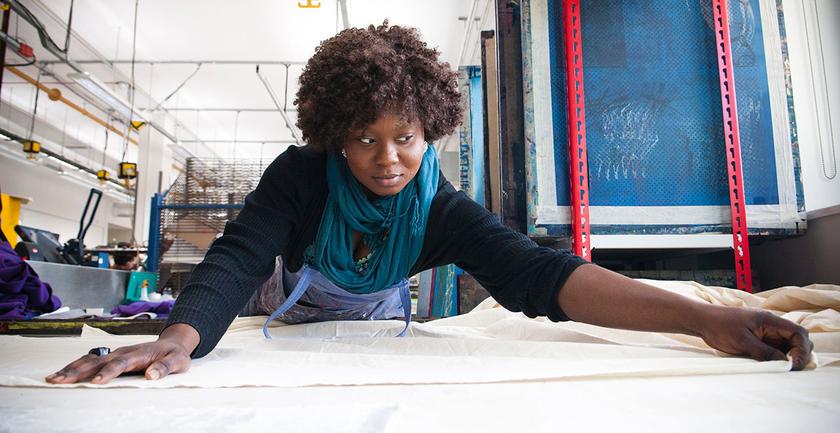 Student stretches large sheet ready to be printed