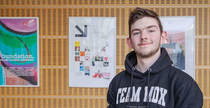 Toney - clearing student stood in front of gallery of work