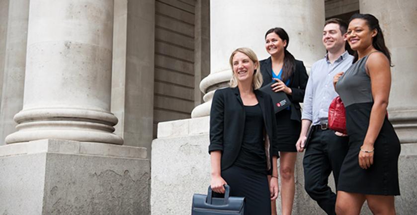 A diverse group of business professionals standing outside a modern building.