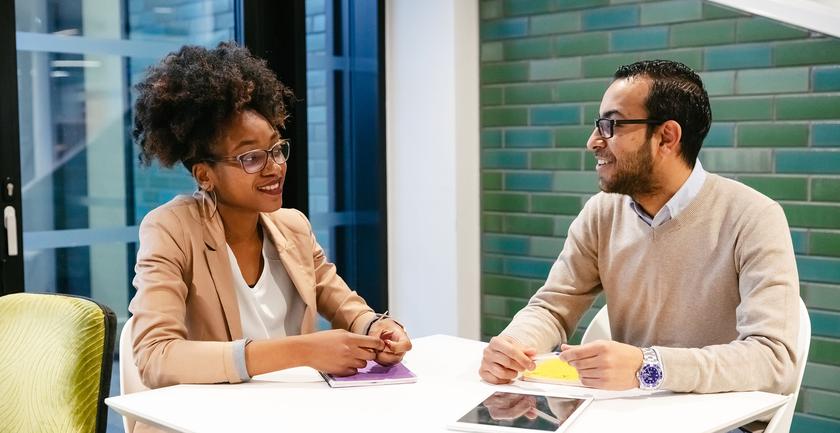 two students have discussion at table