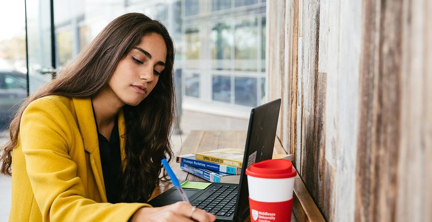 student making notes at desk